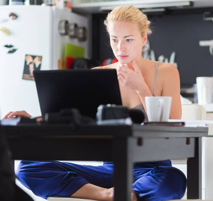 Young lady working remotely from her home kitchen